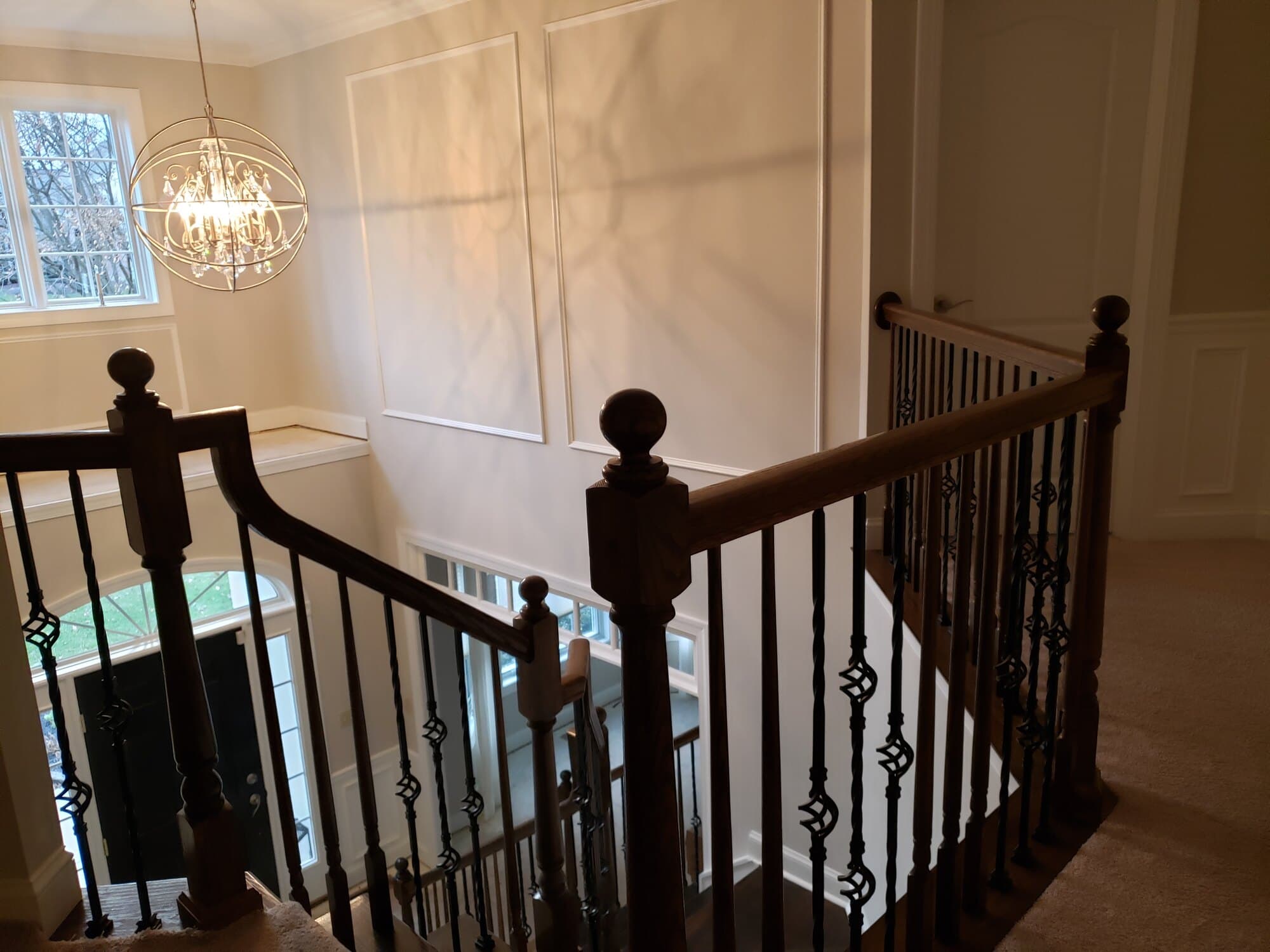 Dark-stained oak treads and railing with basket-twist iron before the white-oak and iron rebuild — Modern White Oak, Lehigh Valley