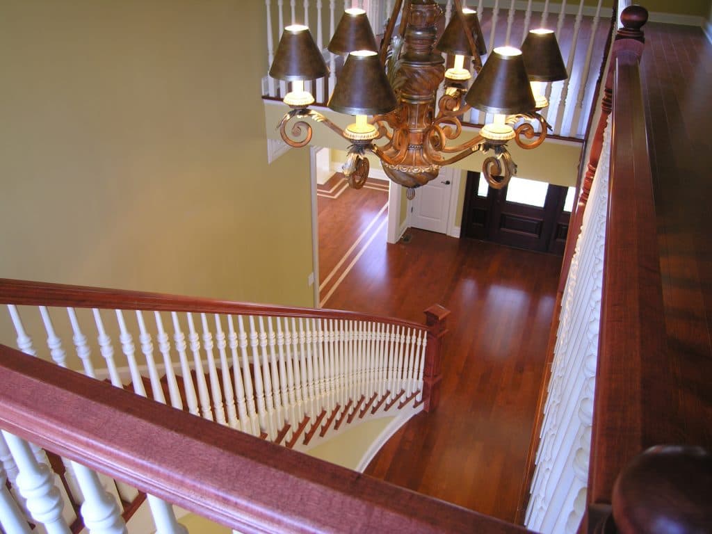 Over-the-post wood handrail flowing over turned newel
