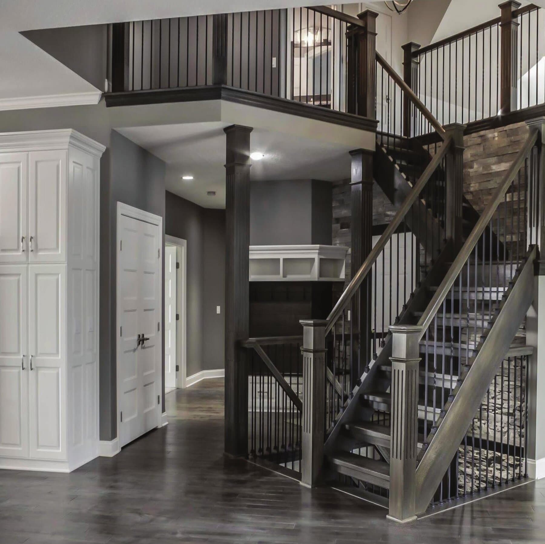 A grand staircase with black iron balusters and dark-wood treads — Snyder Stairs