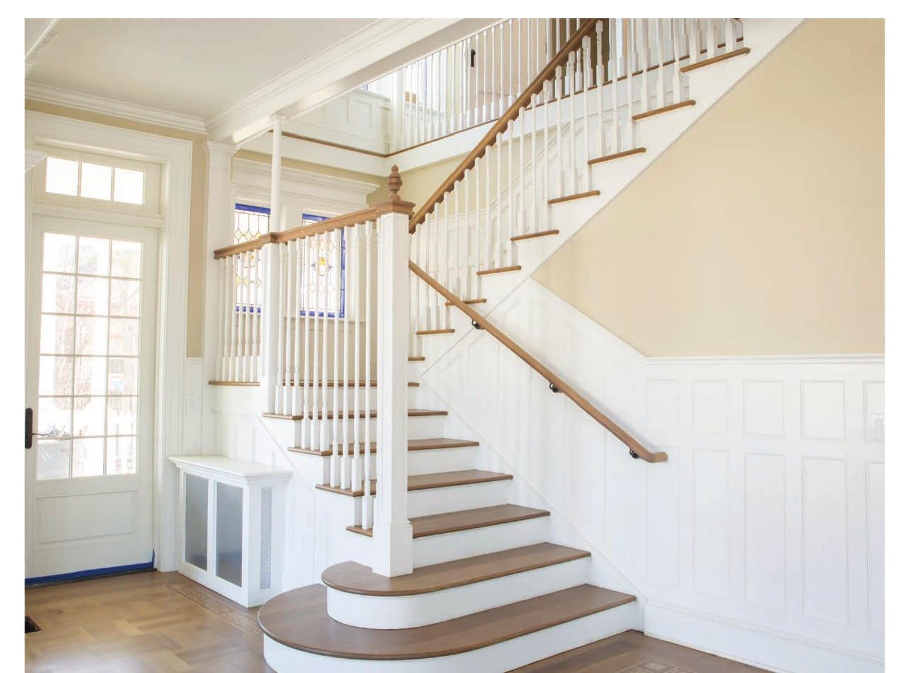 A finished white-oak foyer staircase after a Snyder remodel