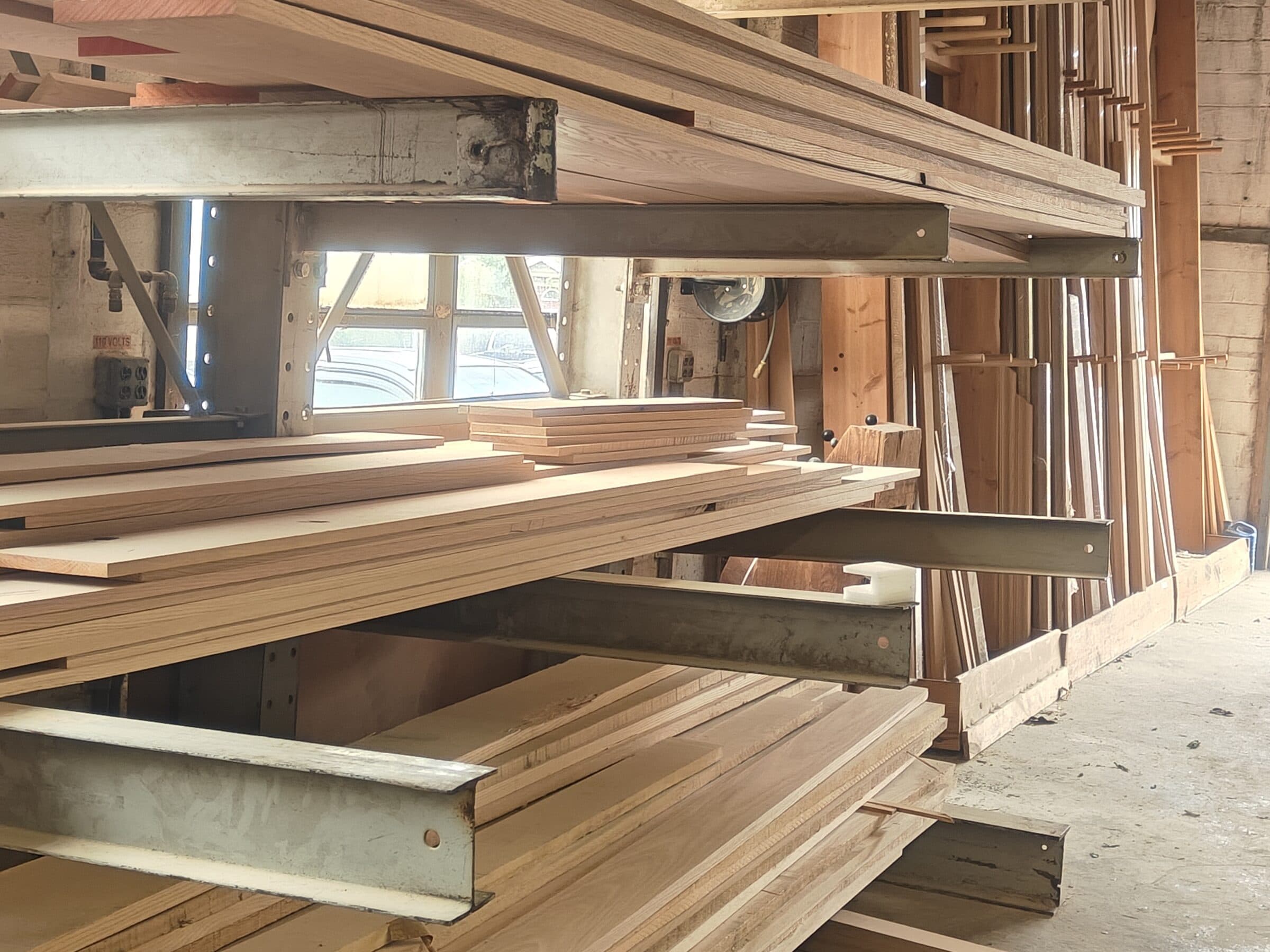 Domestic hardwood staged on lumber racks in the Snyder Whitehall shop, ready for fabrication.