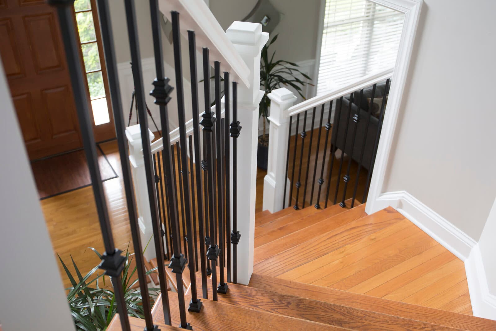Landing with satin-black iron balusters and white newels in a bright foyer — repeating-floorplan community build in the Lehigh Valley