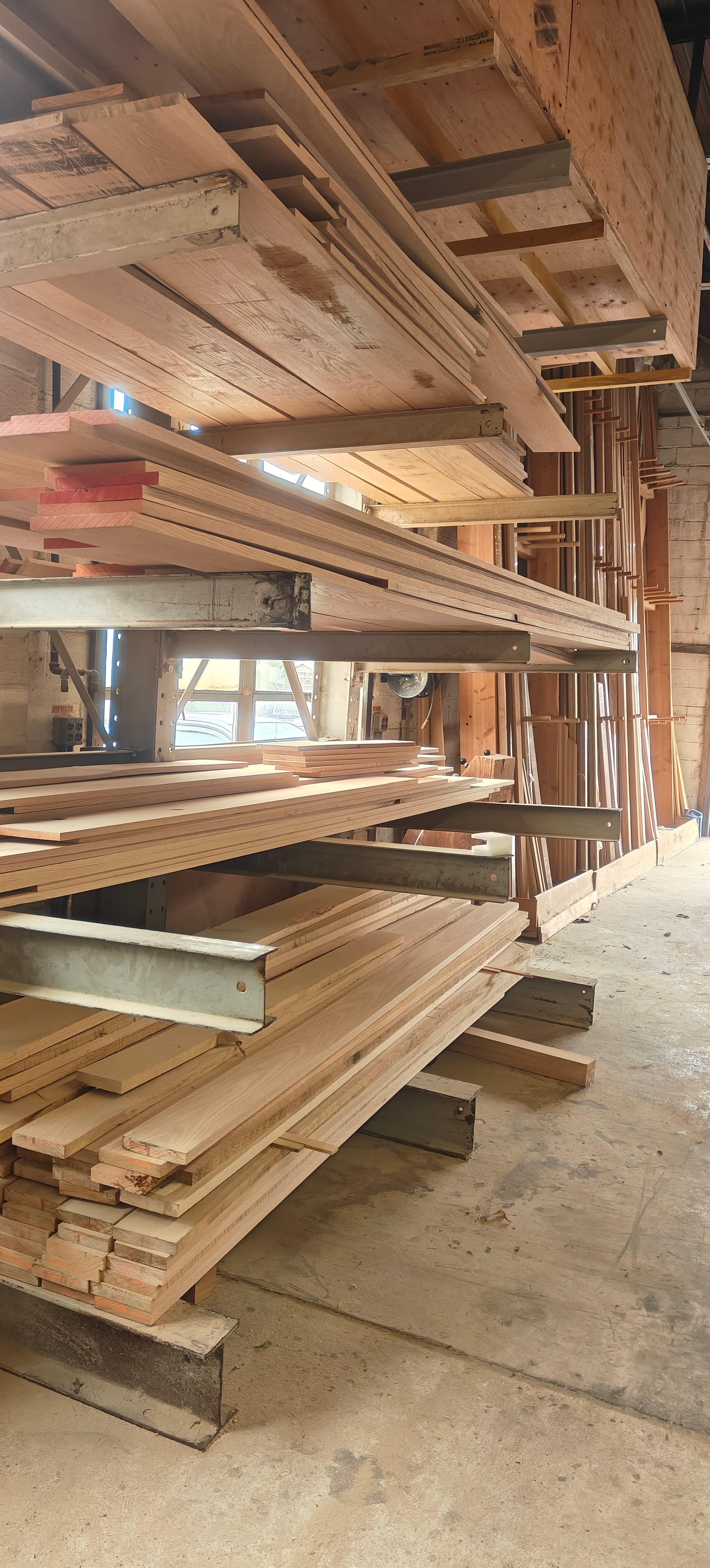 Snyder Stairs lumber library — hardwood boards racked vertically in the Whitehall shop