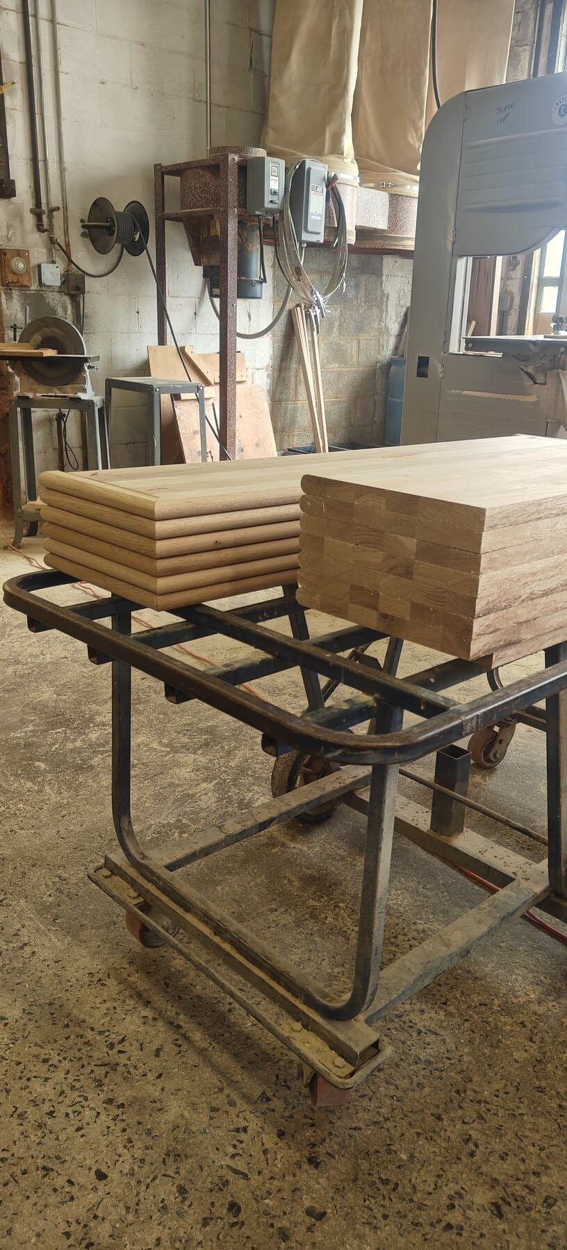 Finished hardwood tread blanks stacked on a shop cart in the Snyder Stairs Whitehall shop