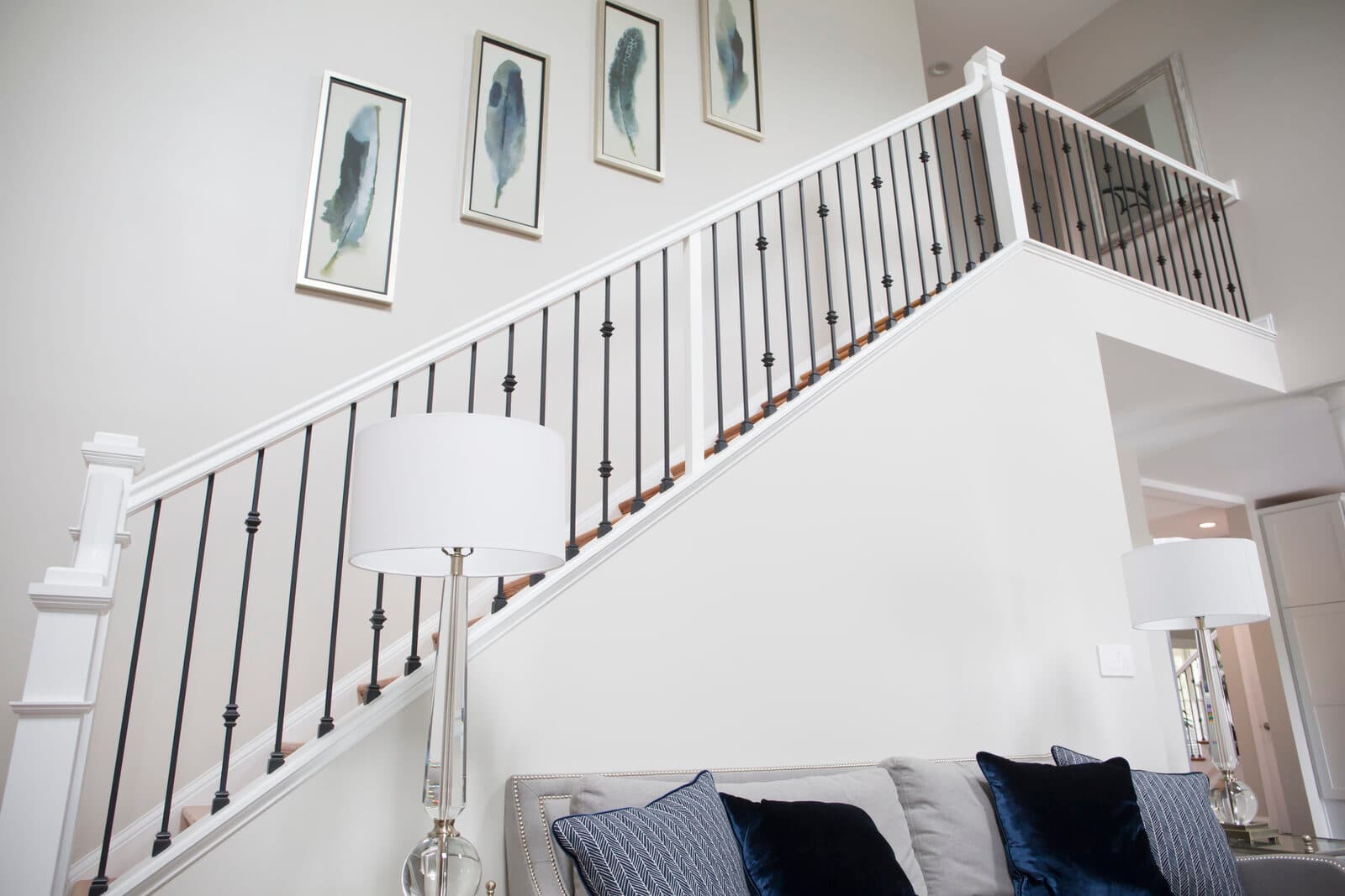 Satin-black iron balusters on a white staircase climbing to the landing