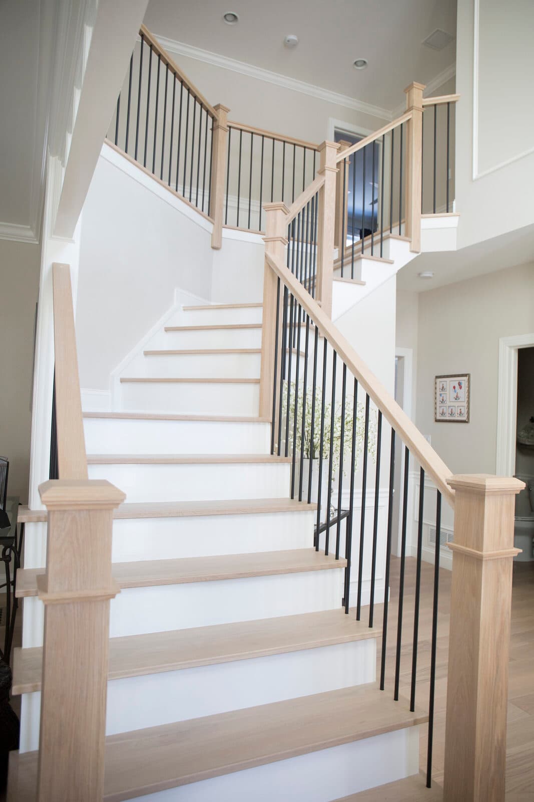 Satin-black iron balusters on a natural white-oak staircase — Lehigh Valley install