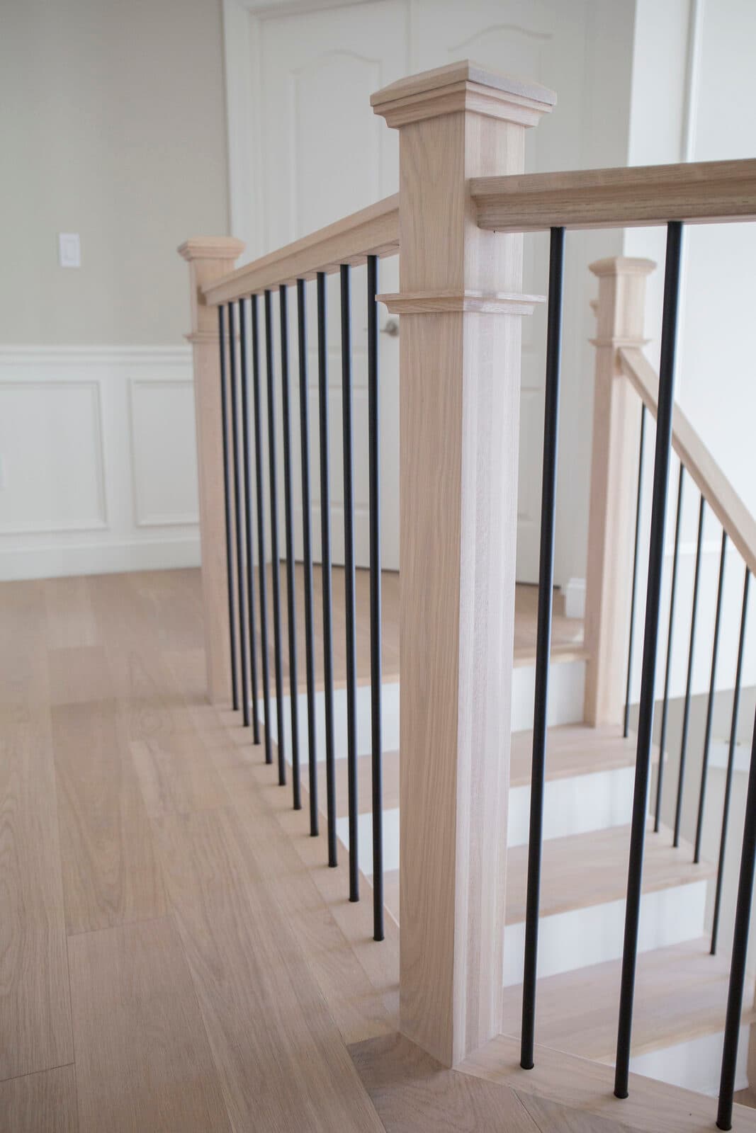 Single-family community model-home landing with a white-oak and black-iron staircase in a Lehigh Valley subdivision