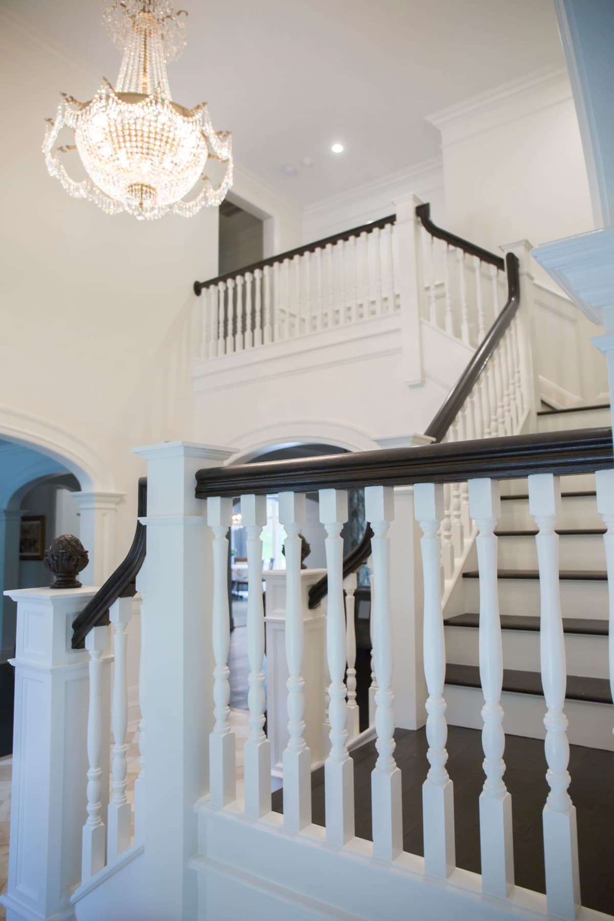 Two-story foyer with a dark-and-white multi-run staircase and chandelier — Caruso residence, Bethlehem