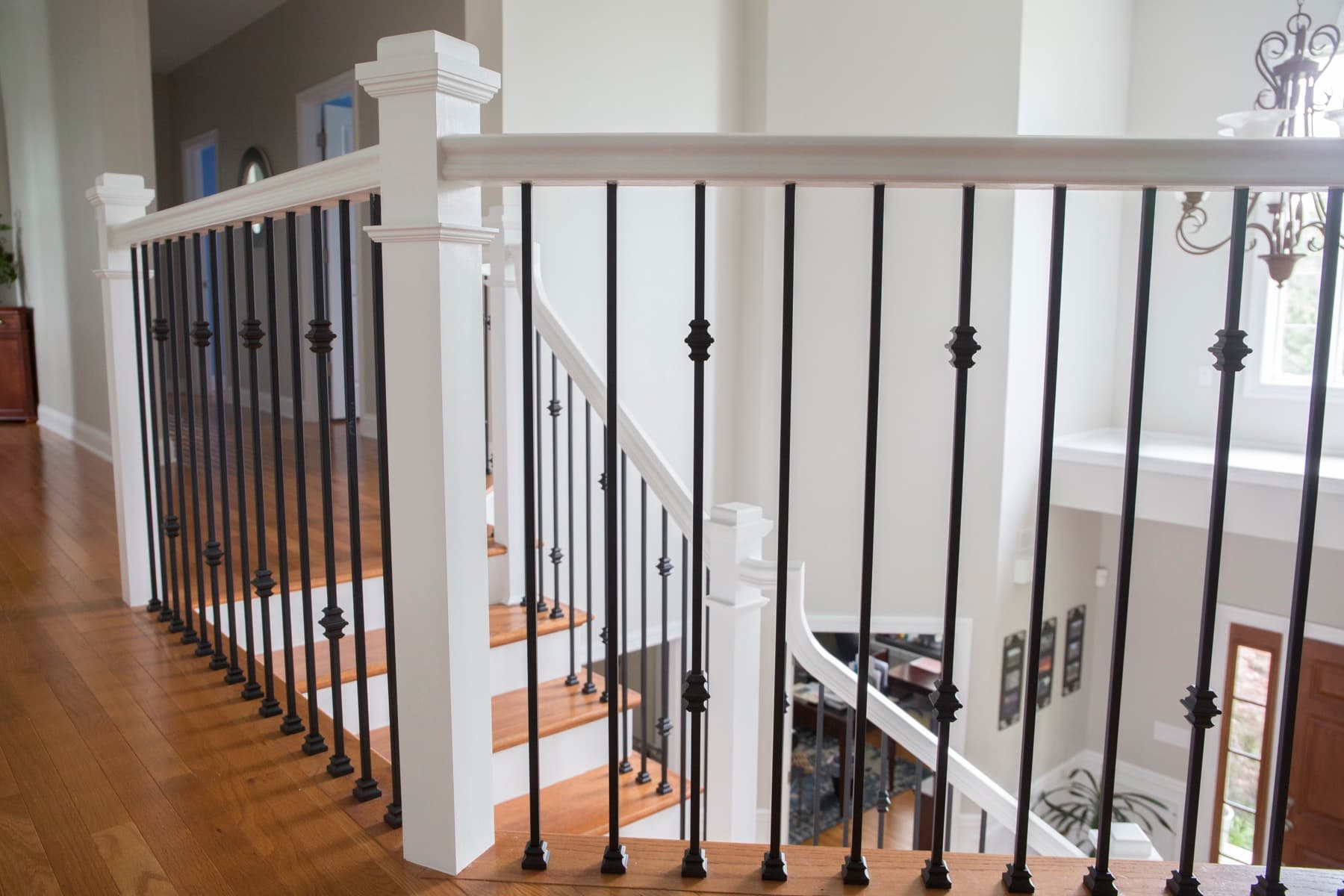 Balcony railing detail with knuckle iron balusters meeting a white box newel — Center Valley project