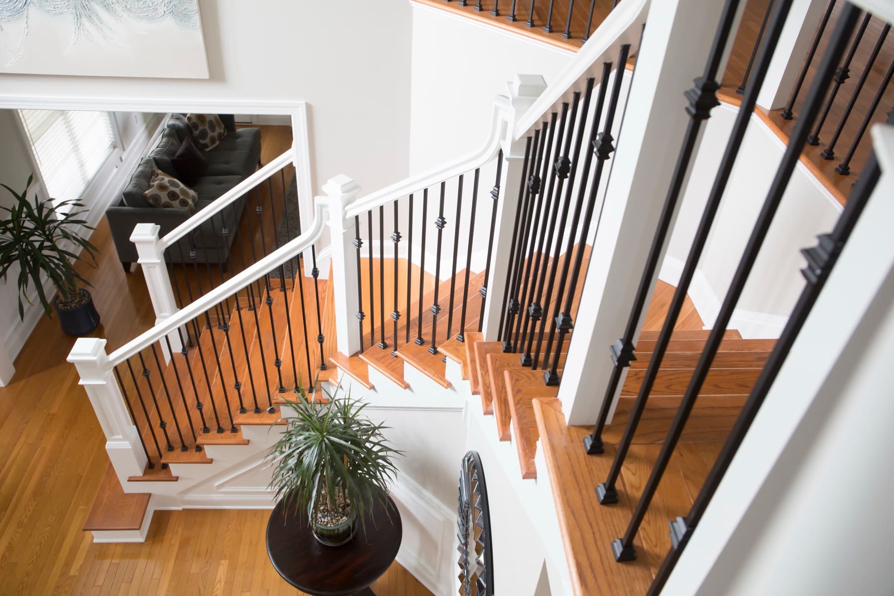 Transitional staircase with powder-coated iron balusters and an oak handrail — Center Valley residence