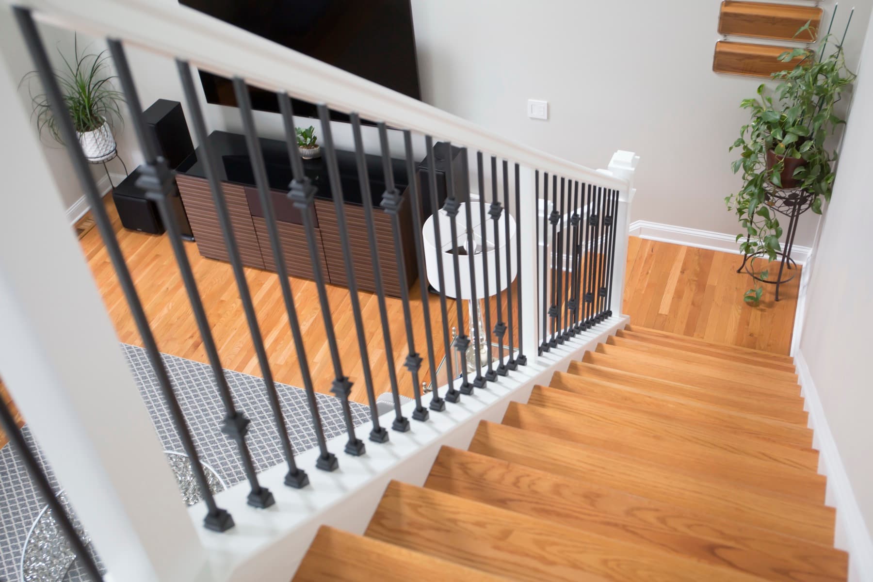 Contemporary stair with square-stock satin-black iron balusters over light hardwood treads