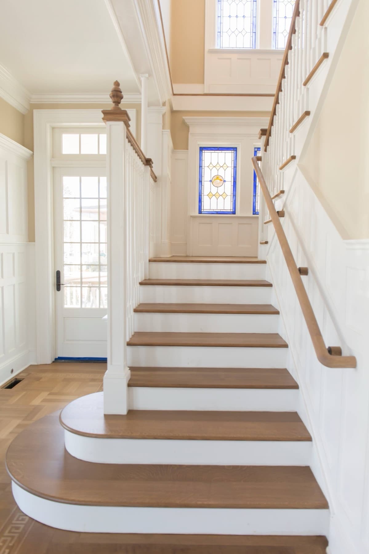 Foyer view up the stair from the curved base — Faucett period restoration