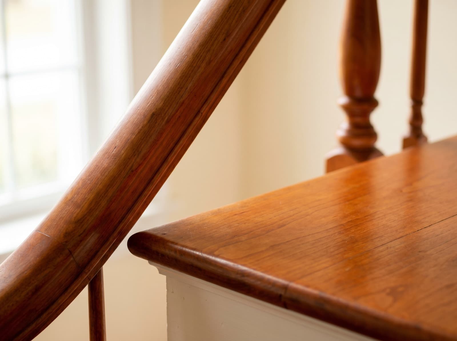 Cherry handrail and tread with turned balusters — warm amber patina
