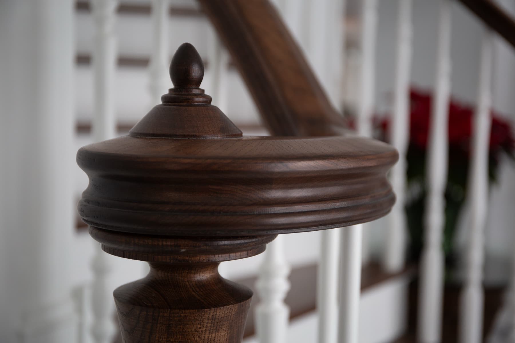 Hand-carved walnut volute and newel detail — Rambo residence craft close-up