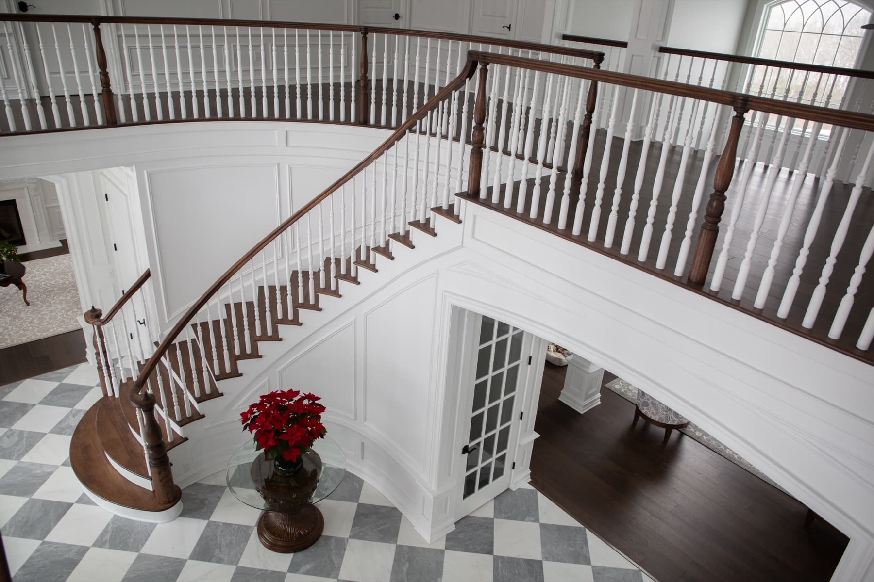 Atmospheric walnut staircase landing with brass detail — Rambo residence